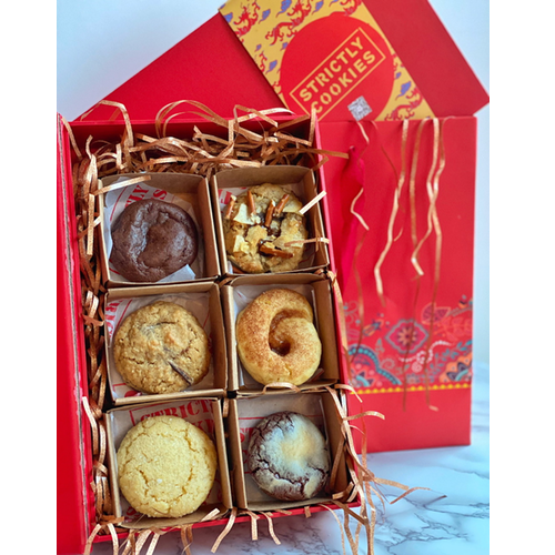 a red cookie box filled with 6 different types of soft and round cookies