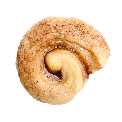 a round sugar cookie with a coating of cinnamon and sugar with a swirl of cinnamon goo in the middle